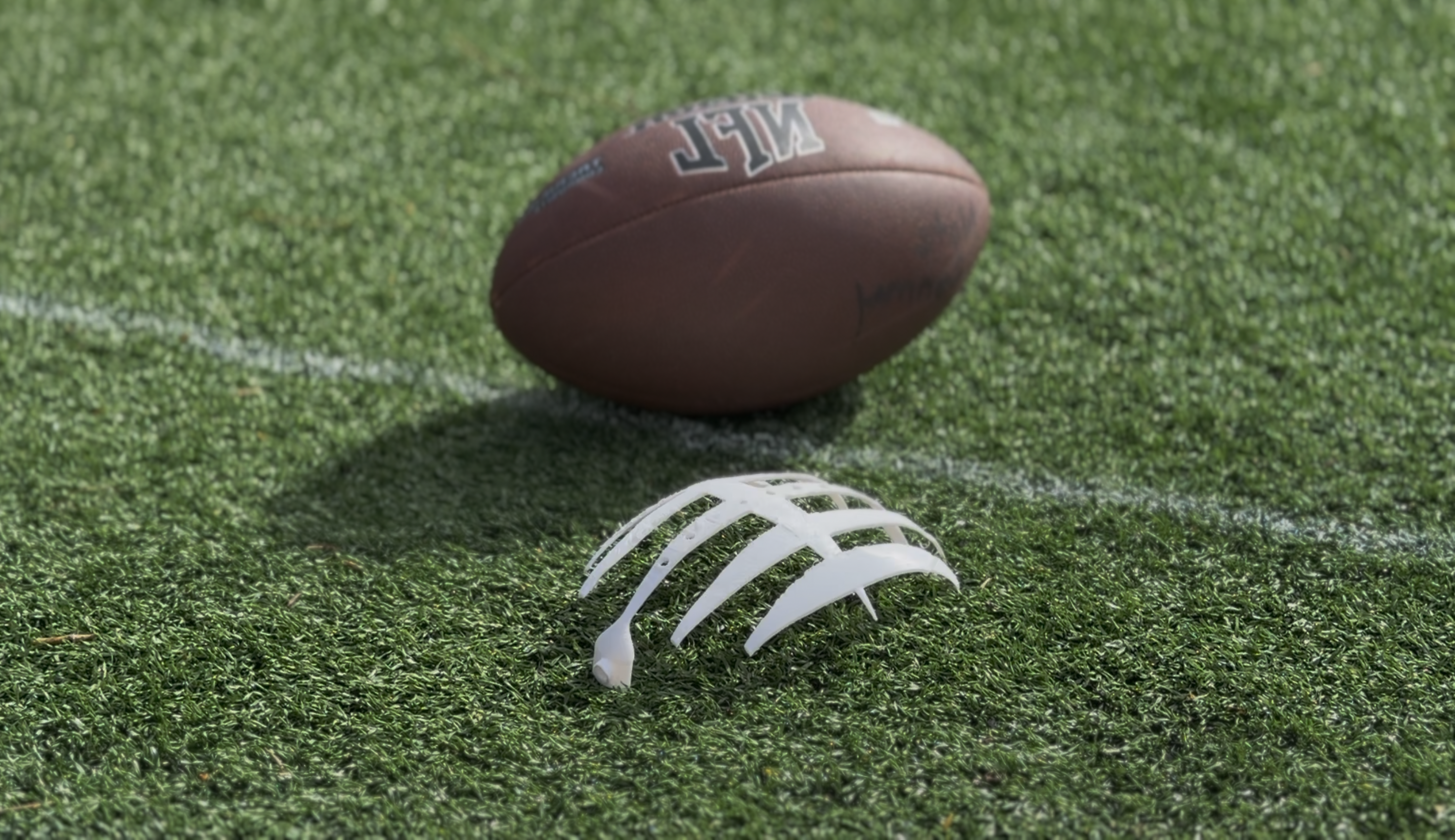 3D-printed Halo prototype on turf with a football
